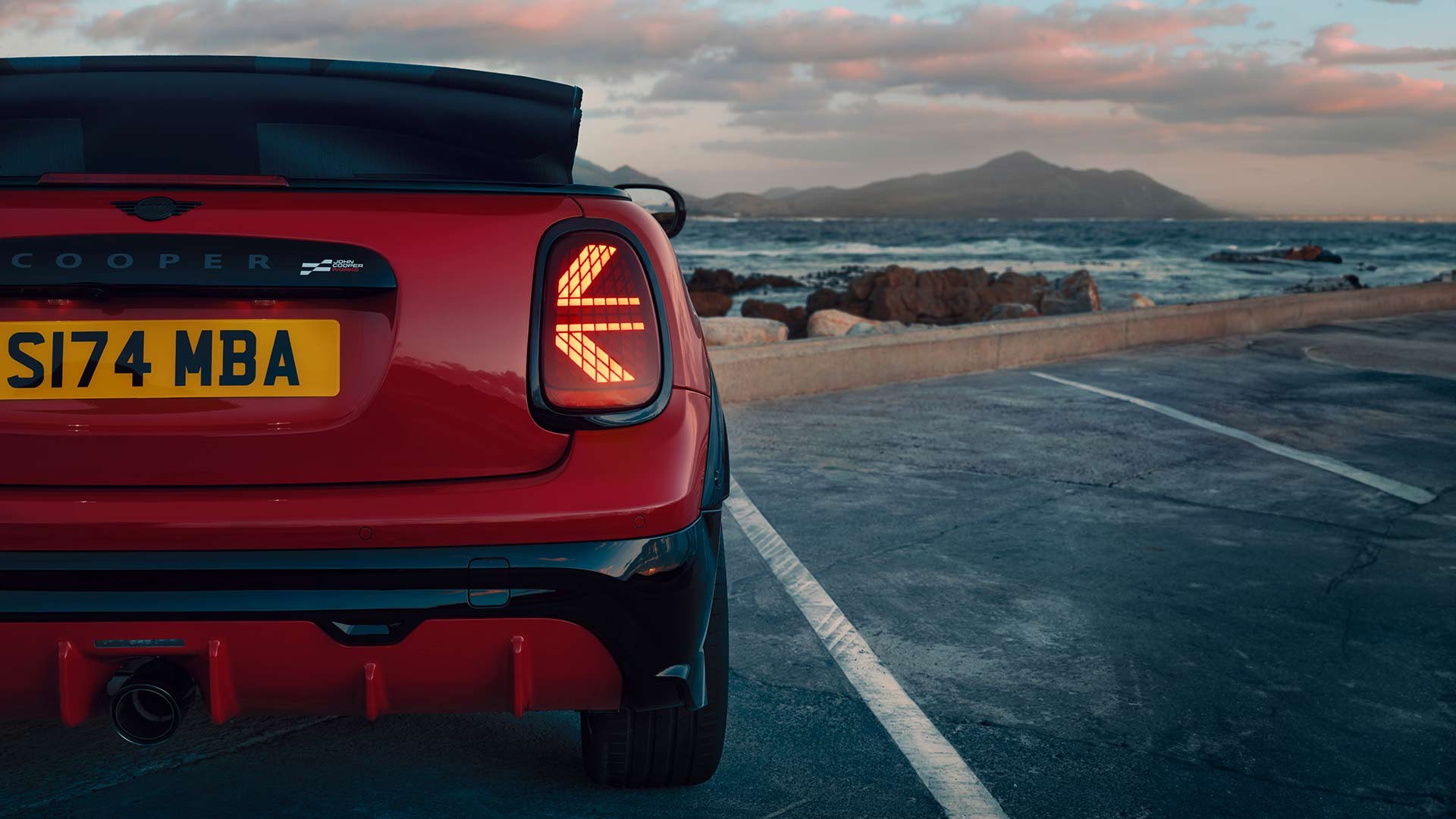 Draufsicht auf ein MINI Cooper Cabrio in Copper Grey mit MINI Yours Verdeck, das am Straßenrand parkt